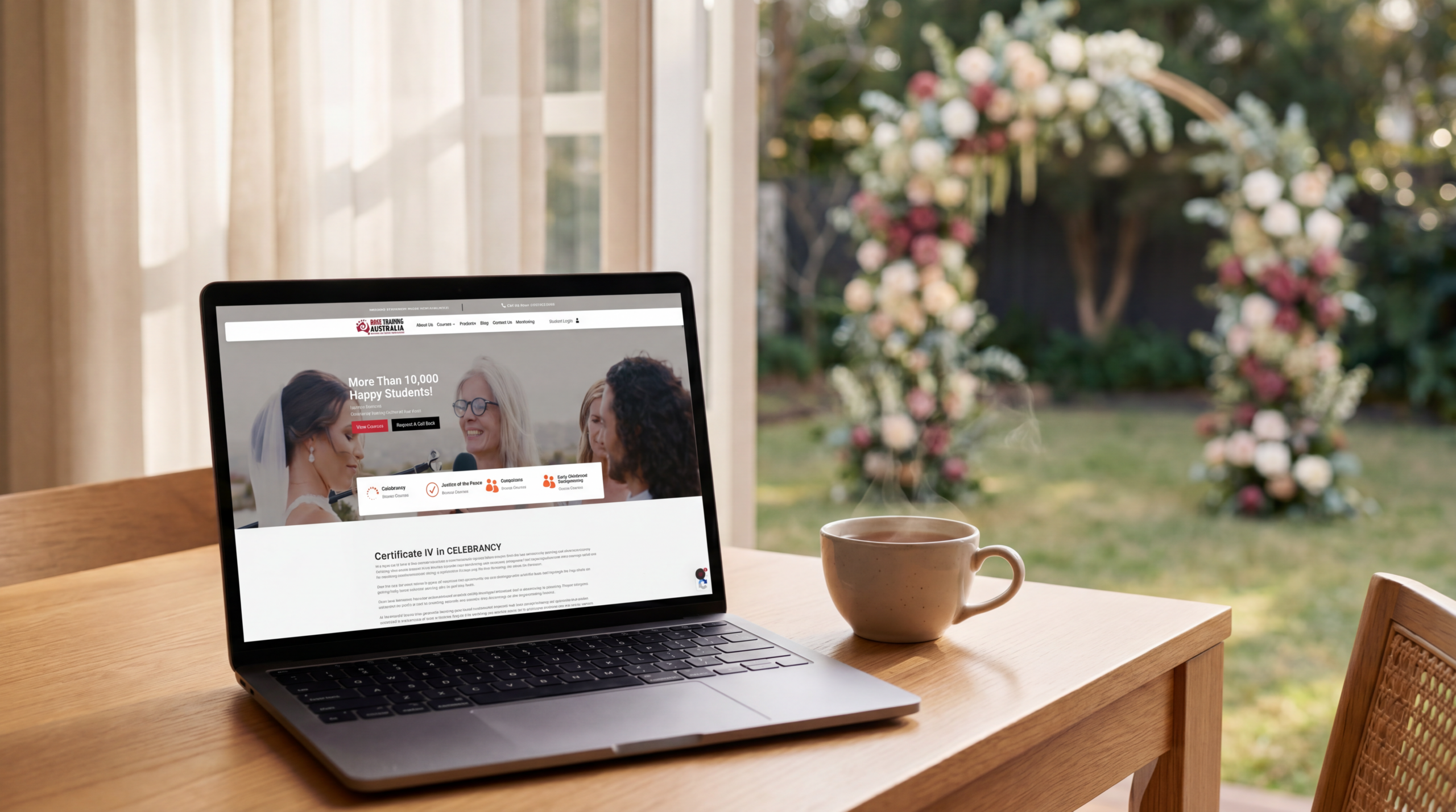 Laptop showing the Rose Training Australia website on a warm desk with a wedding ceremony arch behind it, representing studying celebrancy online in Australia